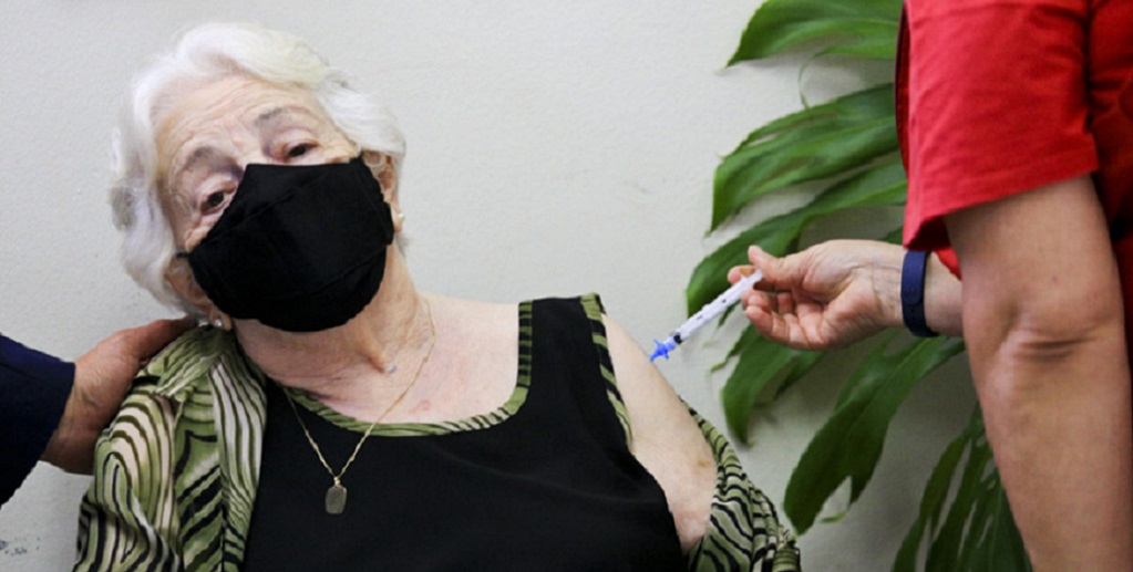 Zita Ferreira Magalhães, 104 anos, recebe a primeira dose da vacina contra a Covid-19, na UBS 1 do Guará/ Breno Esaki/Agência Saúde DF